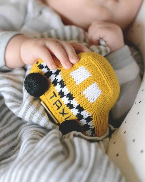 baby holding taxi rattle