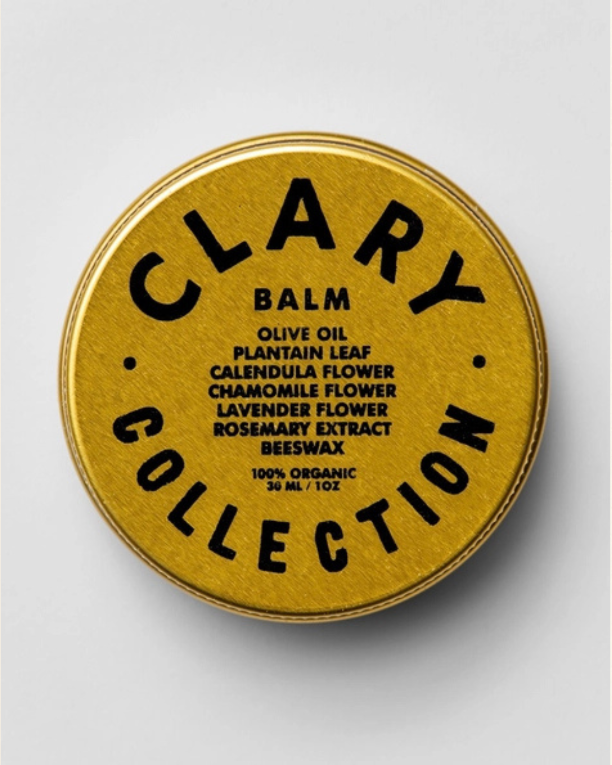 A yellow tin container labeled 'CLARY COLLECTION Balm' with text detailing the ingredients such as olive oil, plantain leaf, calendula flower, chamomile flower, lavender flower, rosemary extract, and beeswax.
