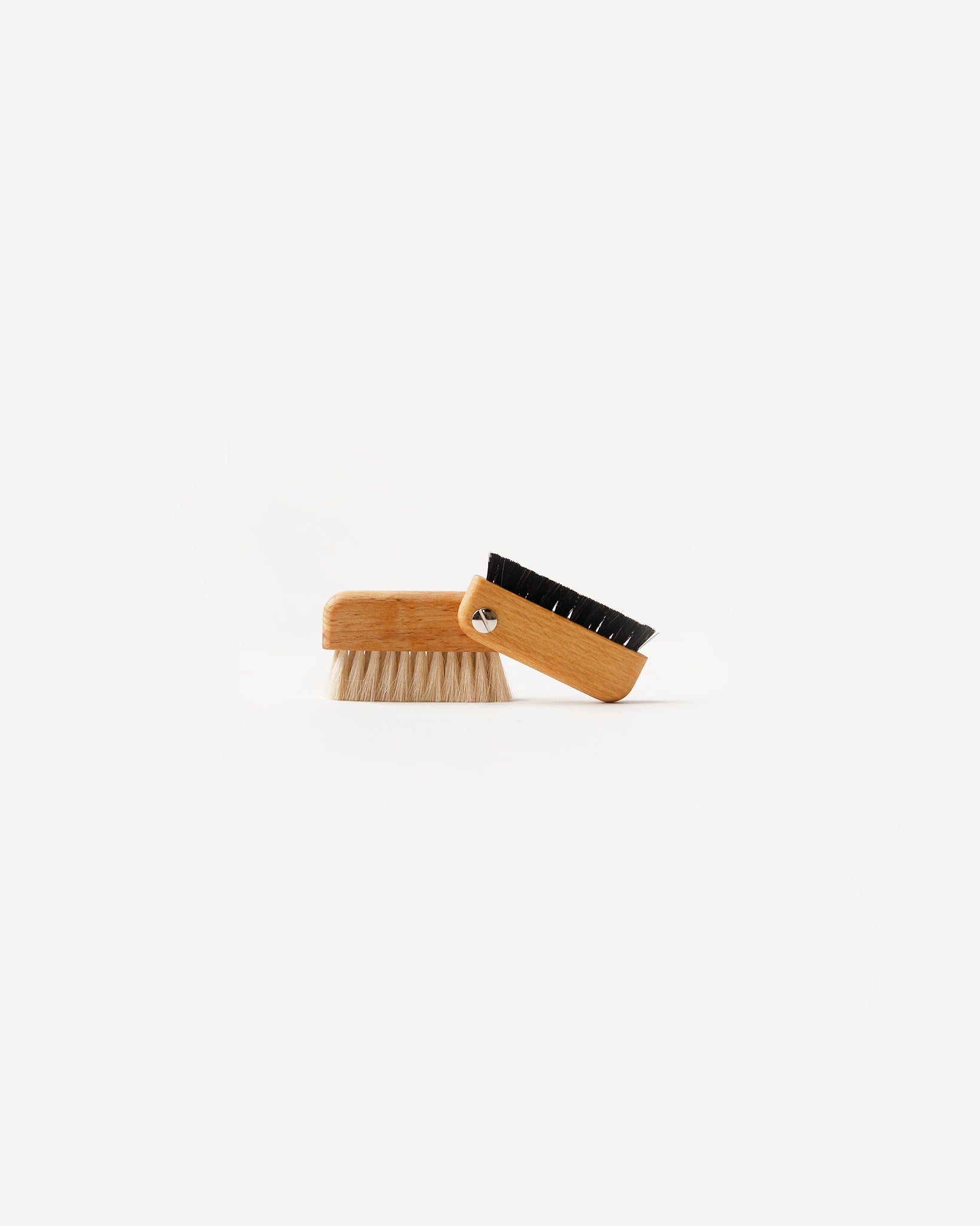 A double-sided laptop brush with a wooden handle and black bristles, designed to clean between the keys of a laptop.