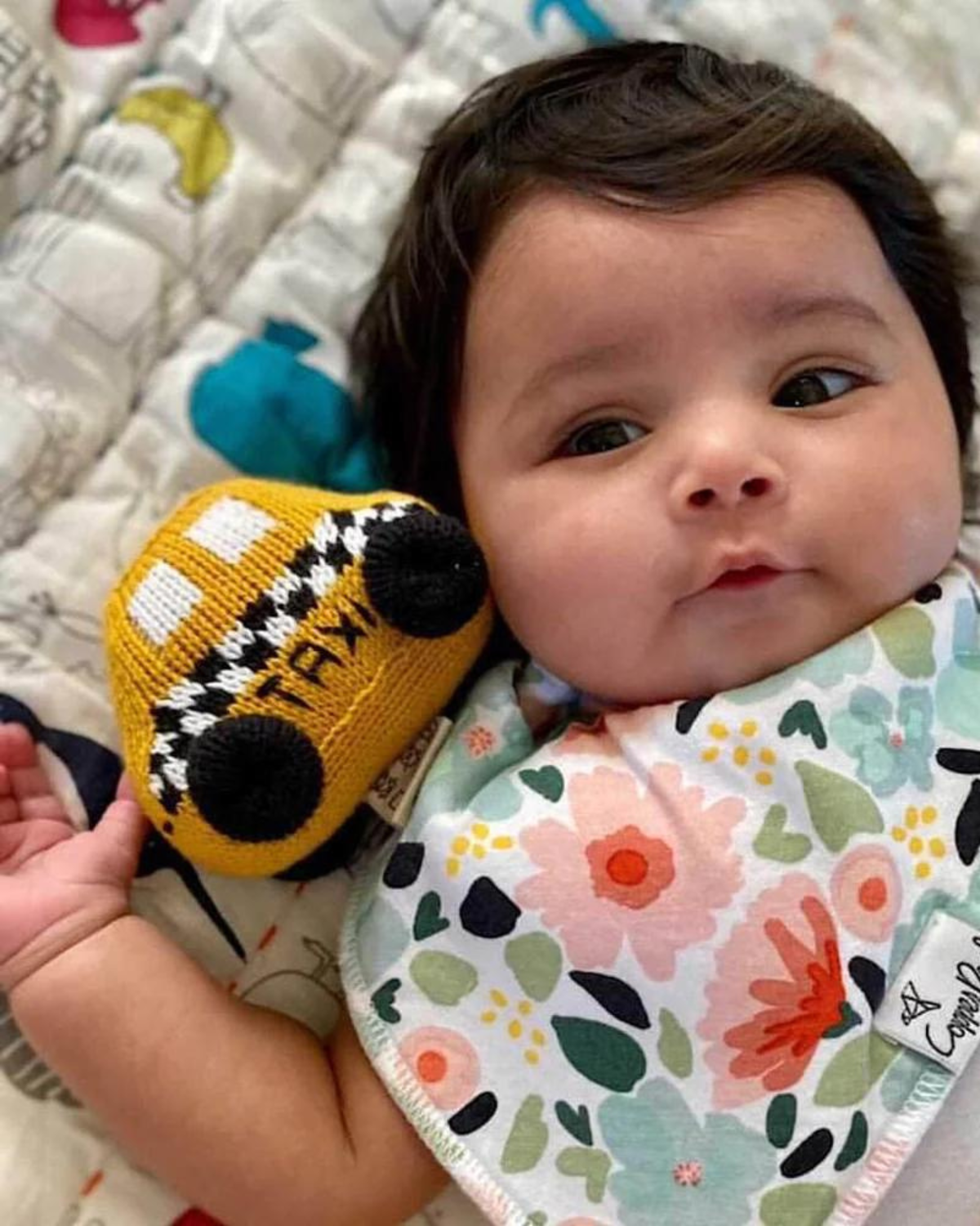 baby holding taxi rattle